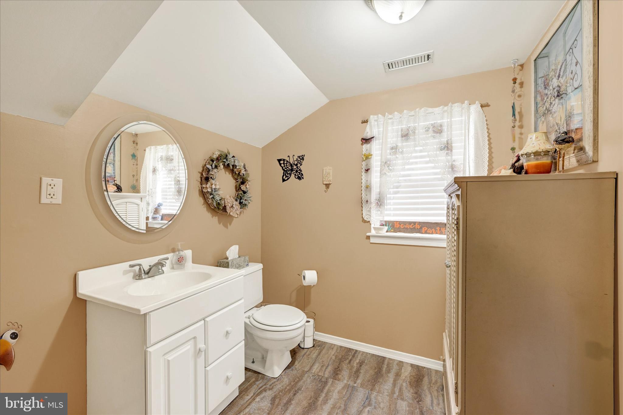 4630 Magnolia Avenue Baltimore, MD 21227 - Photo 17 of 31 a bathroom with a toilet a sink and a mirror