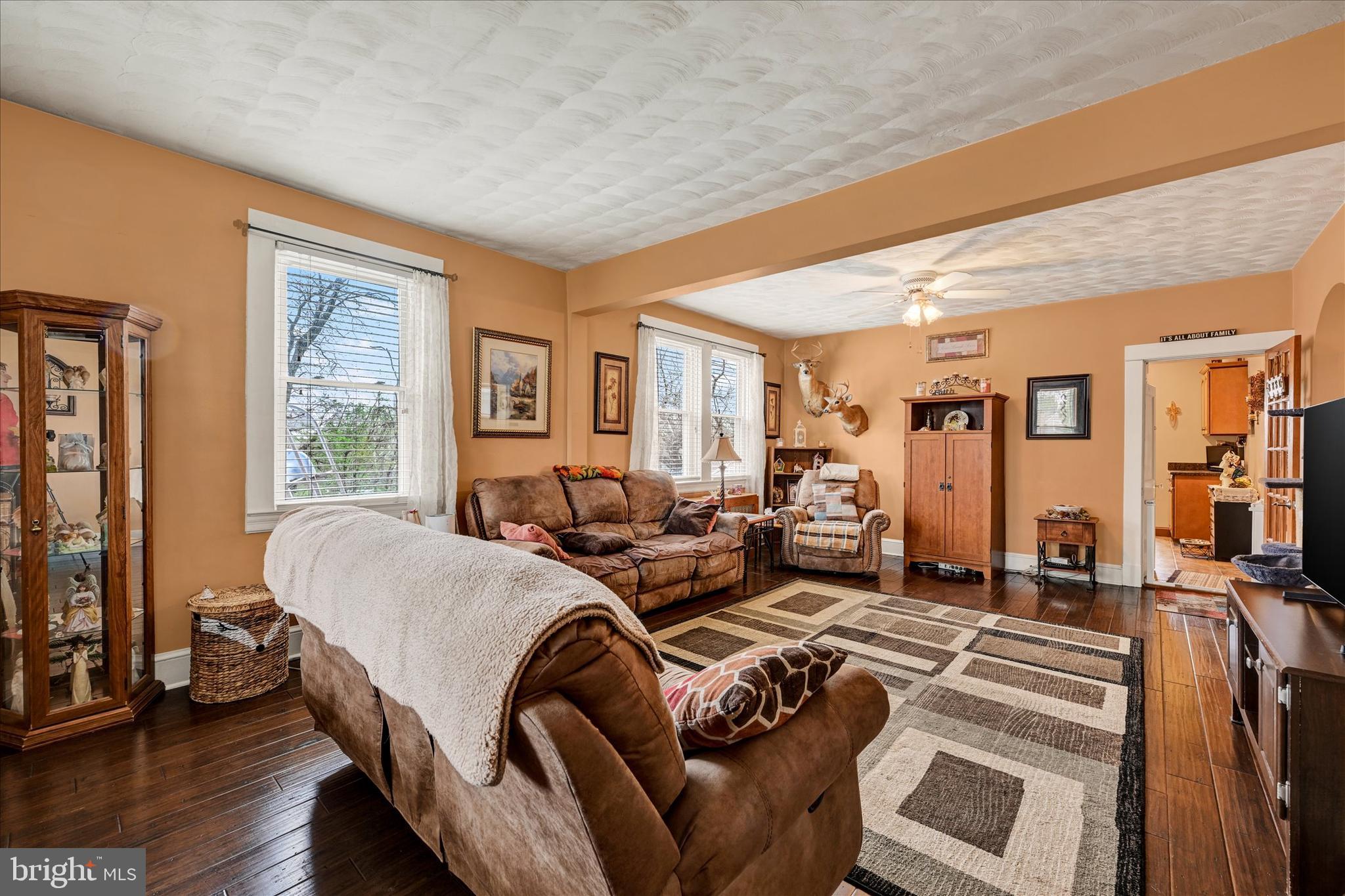 4630 Magnolia Avenue Baltimore, MD 21227 - Photo 5 of 31 a living room with furniture two large window and wooden floor