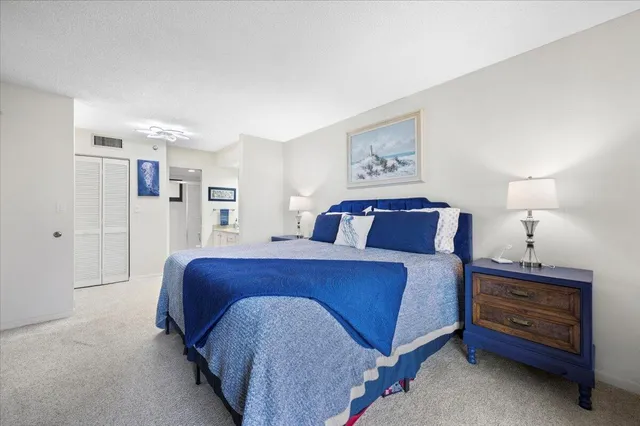 a spacious bedroom with a bed and a lamp