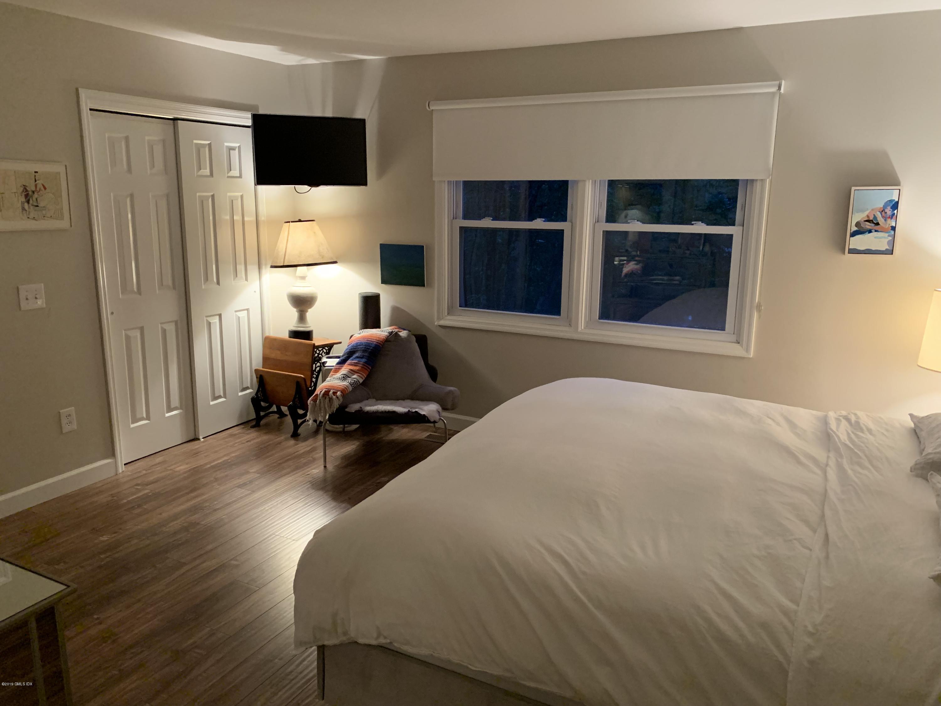 213 River Extension, Unit B Cos Cob, CT 06807 - Photo 11 of 15 a bed room with a bed and a television