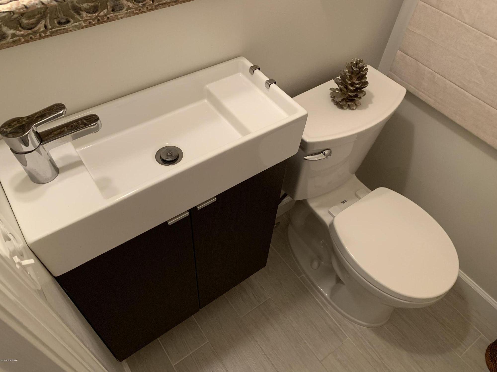 213 River Extension, Unit B Cos Cob, CT 06807 - Photo 15 of 15 a bathroom with a sink toilet and mirror