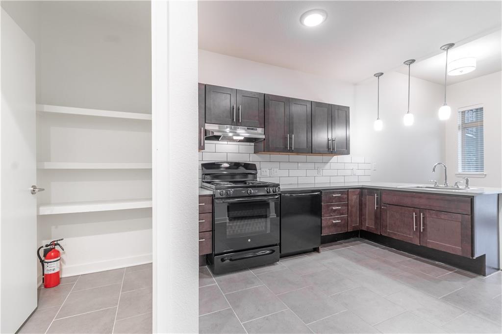 6700 Menchaca Road, Unit 12 Austin, TX 78745 - Photo 12 of 20 a kitchen with stainless steel appliances kitchen island granite countertop a stove and a sink
