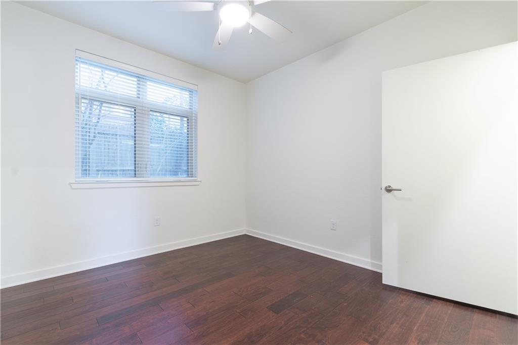 6700 Menchaca Road, Unit 12 Austin, TX 78745 - Photo 15 of 20 an empty room with wooden floor and windows