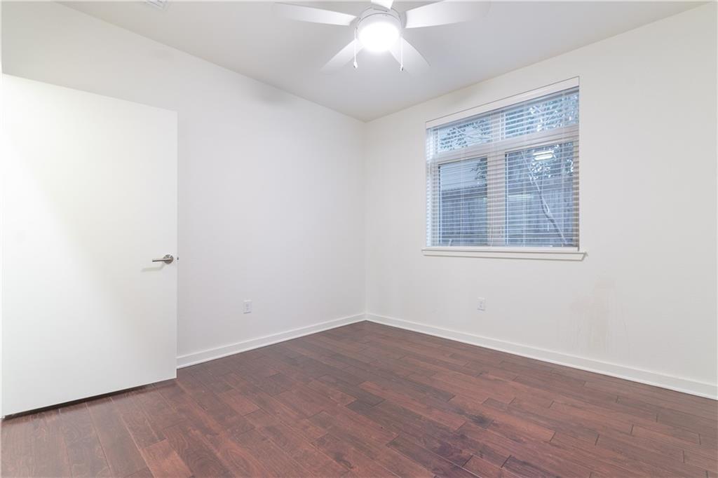6700 Menchaca Road, Unit 12 Austin, TX 78745 - Photo 16 of 20 an empty room with wooden floor and windows