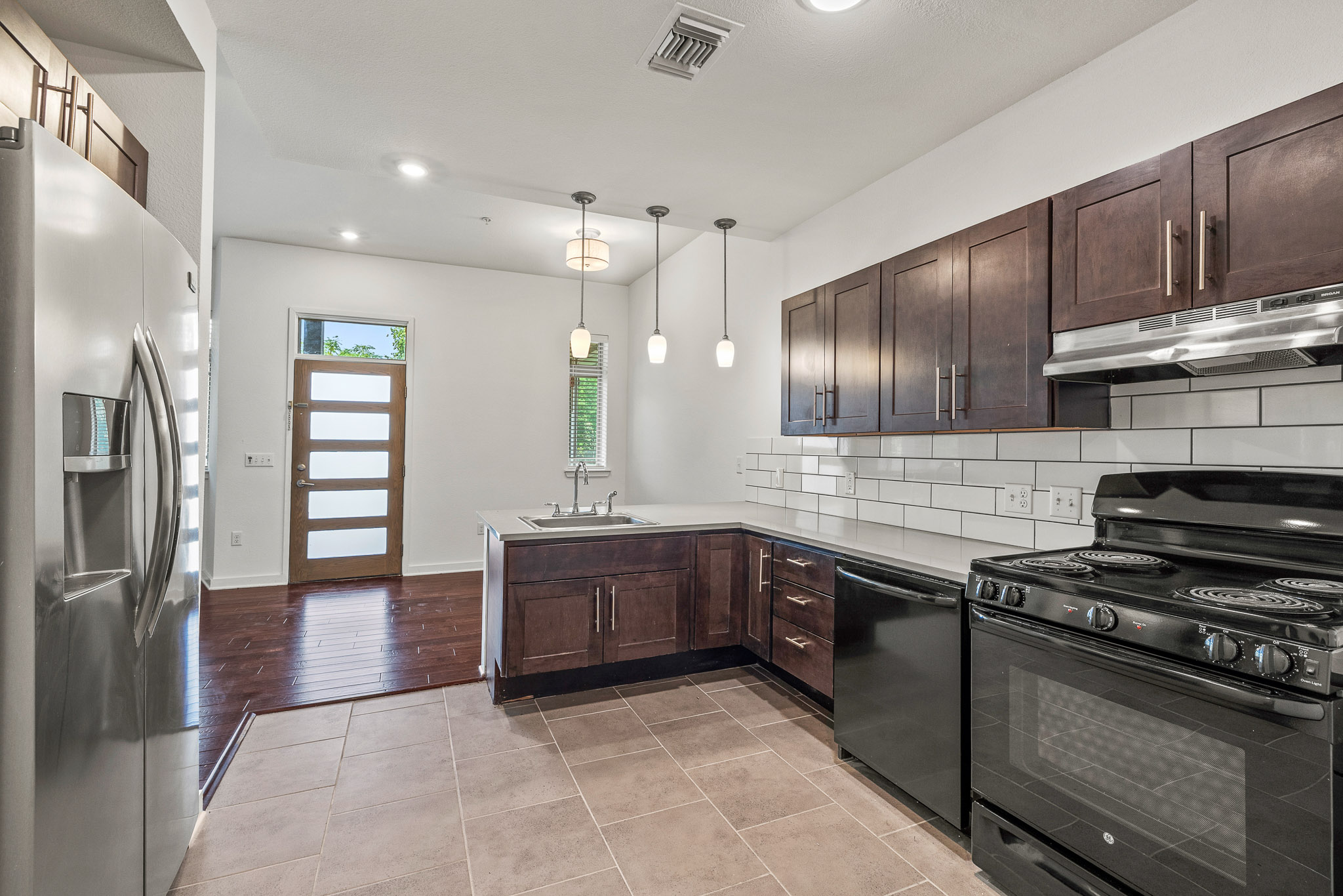 6700 Menchaca Road, Unit 12 Austin, TX 78745 - Photo 2 of 20 a large kitchen with stainless steel appliances granite countertop a stove and a refrigerator