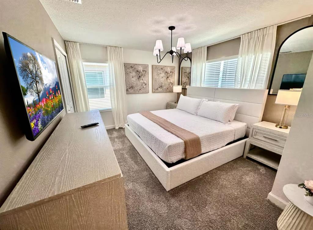 2580 Reading Trail Kissimmee, FL 34746 - Photo 15 of 34 a bedroom with a large bed and a flat screen tv