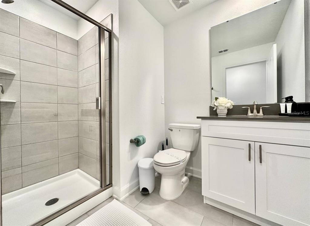 2580 Reading Trail Kissimmee, FL 34746 - Photo 17 of 34 a bathroom with a sink toilet a mirror and shower