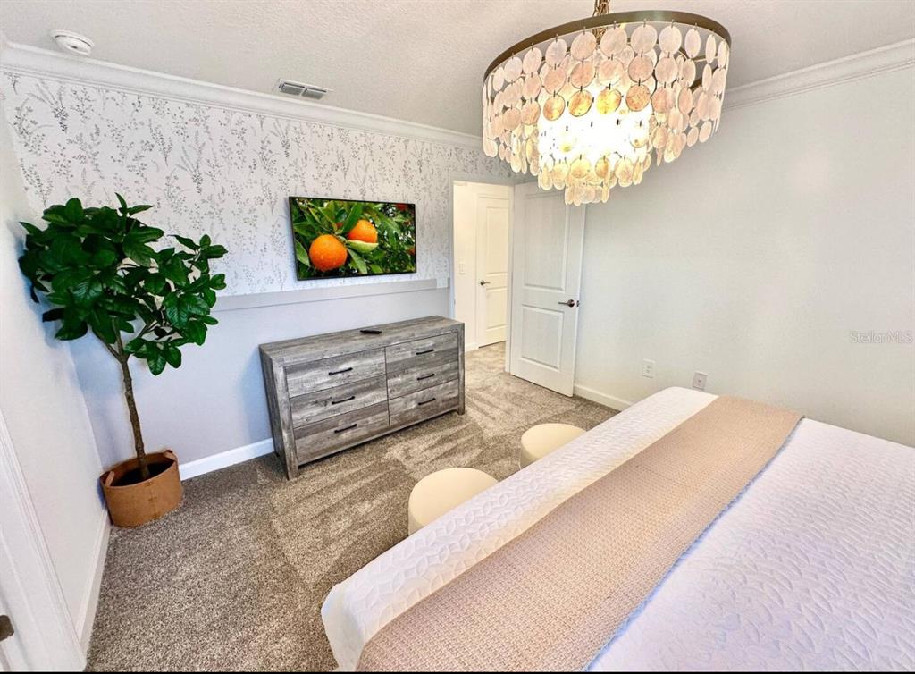 2580 Reading Trail Kissimmee, FL 34746 - Photo 6 of 34 a bedroom with a bed and a chandelier