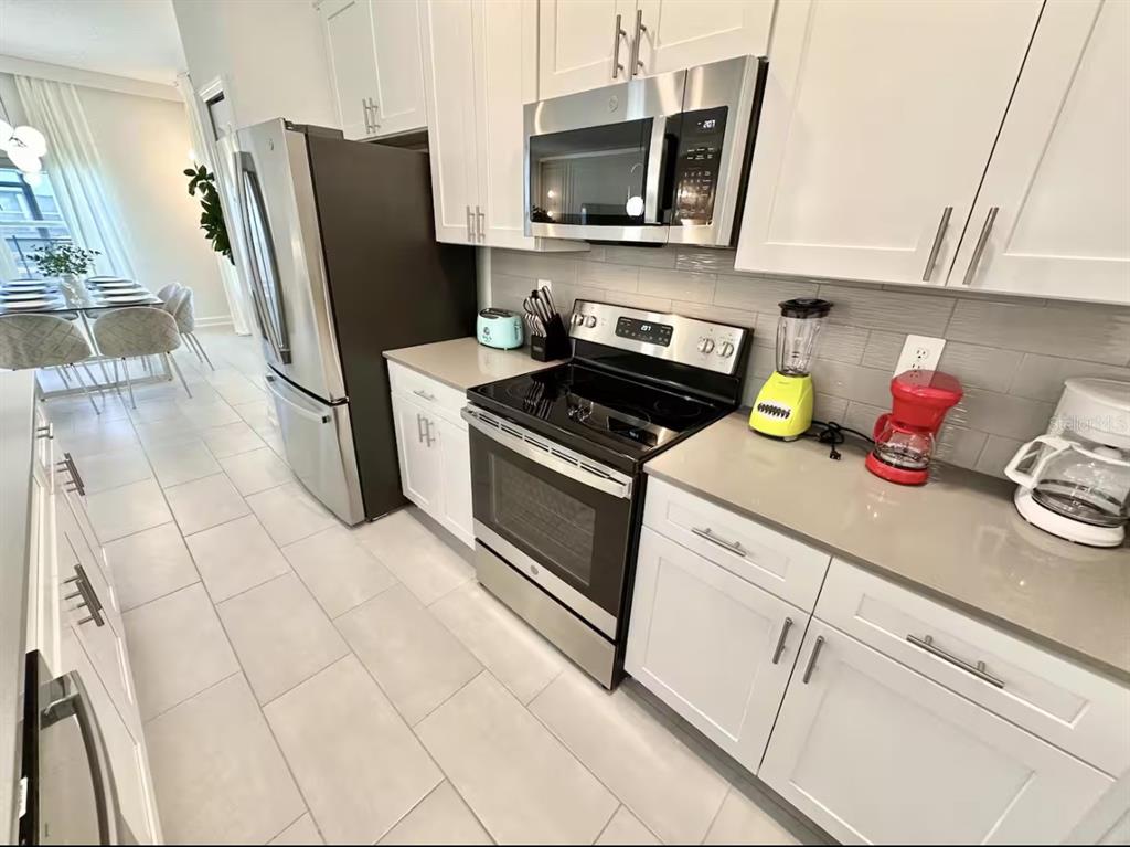 2580 Reading Trail Kissimmee, FL 34746 - Photo 7 of 34 a kitchen with stainless steel appliances a stove microwave and refrigerator