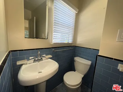 a bathroom with a sink toilet and mirror