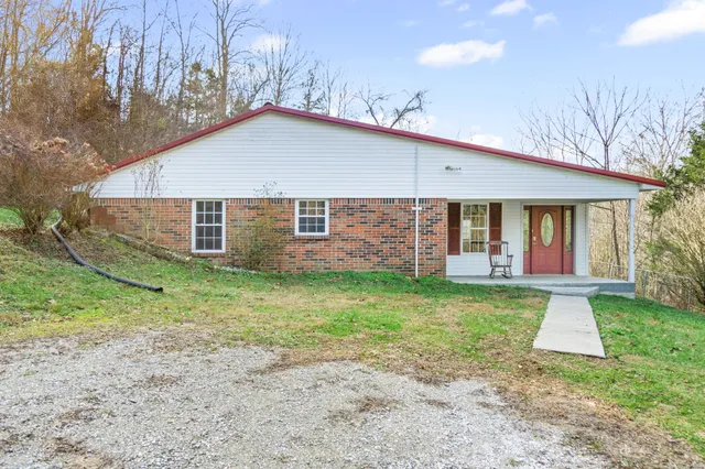 a view of a house with a yard and porch