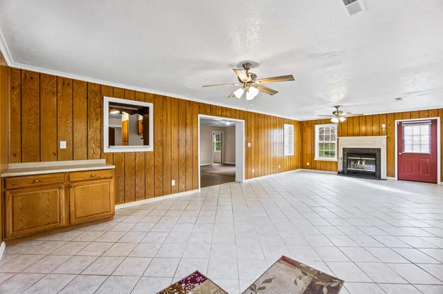 a big room with chandelier fan and windows