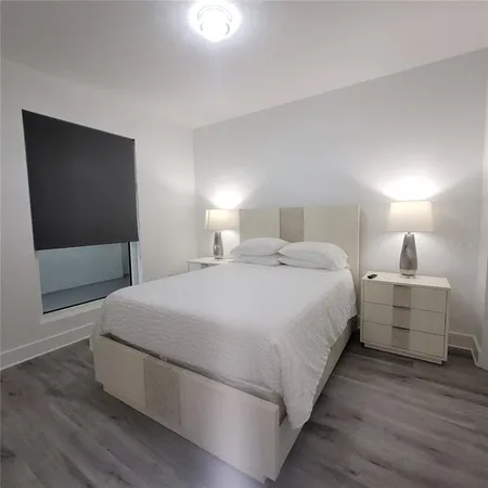 a spacious bedroom with a bed and a flat screen tv