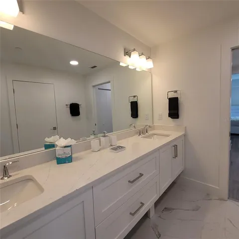 a bathroom with double vanity and a mirror