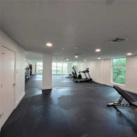 a view of a hall with furniture and windows