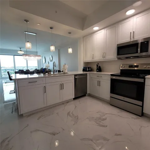 a kitchen with stainless steel appliances granite countertop a sink and a stove