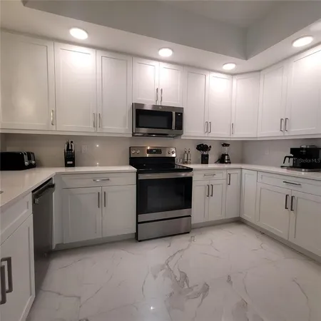 a kitchen with cabinets stainless steel appliances and a window