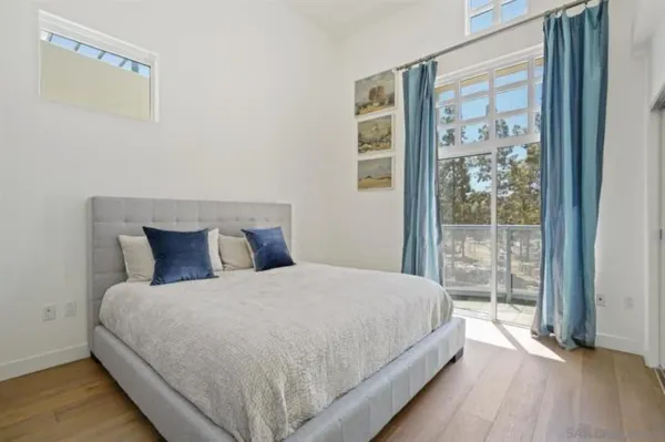 a large bed sitting in a bedroom next to a window
