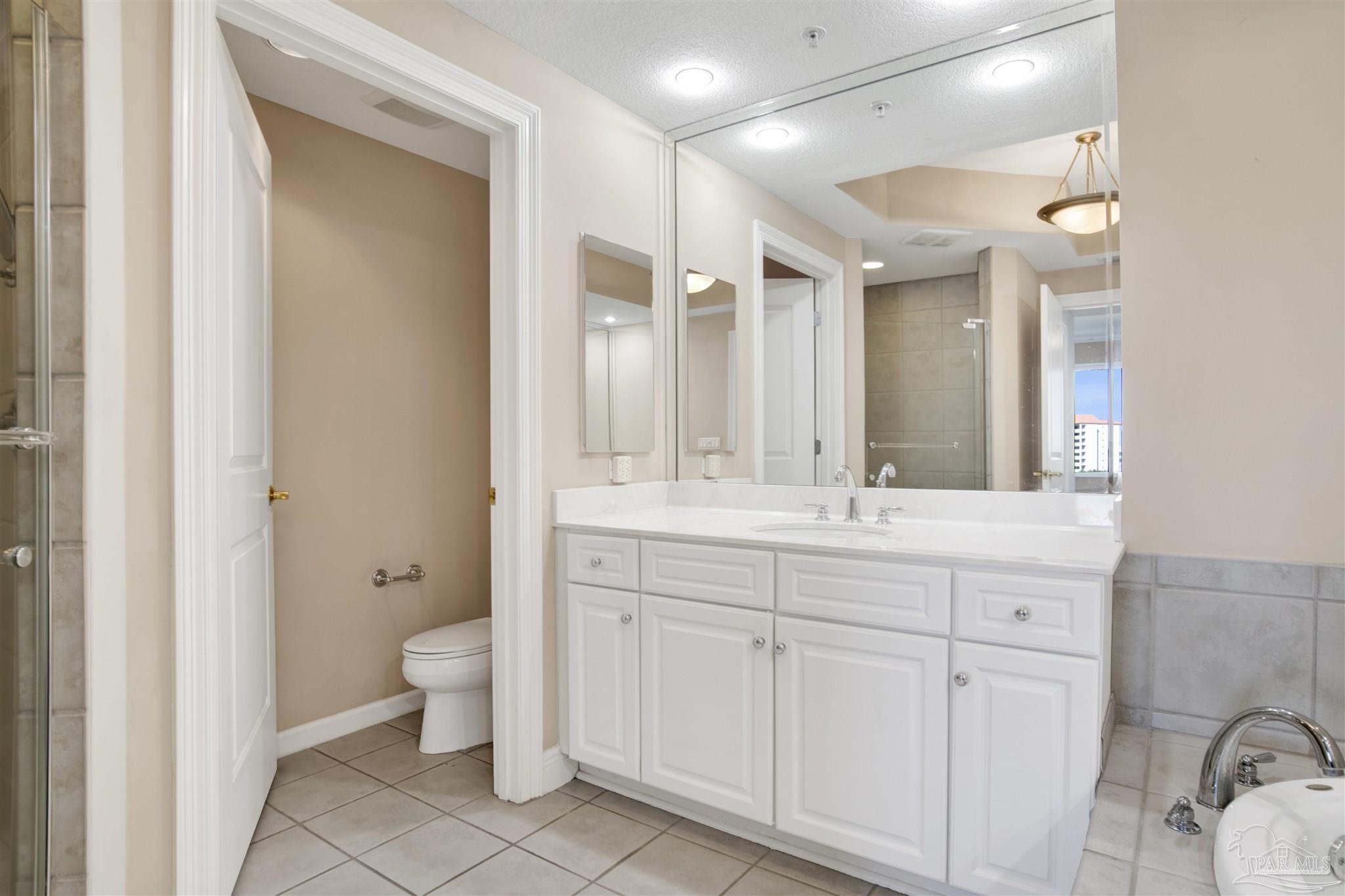 608 Lost Key Drive, Unit 701C Pensacola, FL 32507 - Photo 23 of 32 a bathroom with a granite countertop sink mirror and toilet