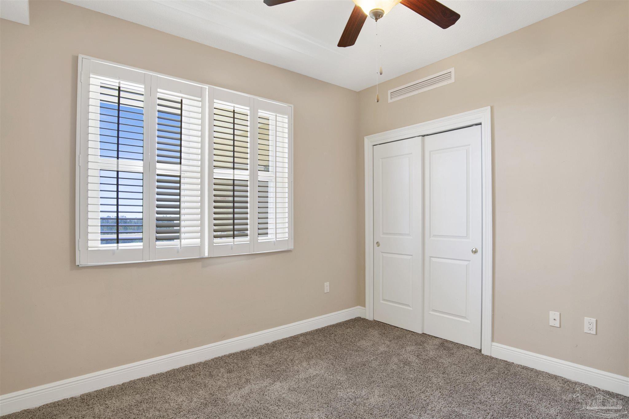608 Lost Key Drive, Unit 701C Pensacola, FL 32507 - Photo 5 of 32 an empty room with chandelier fan and windows