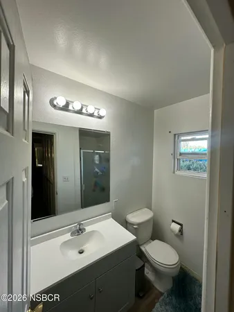 a bathroom with a sink mirror and toilet