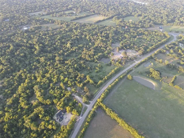 a green field with lots of trees in the background