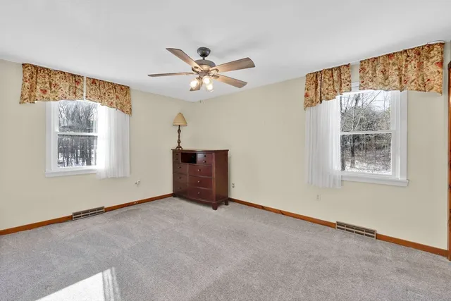 a view of an empty room and cabinet with ceiling fan