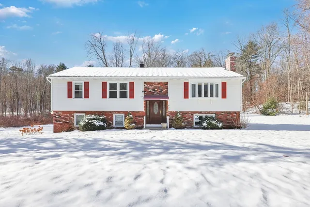 a front view of a house with a yard covered in snow