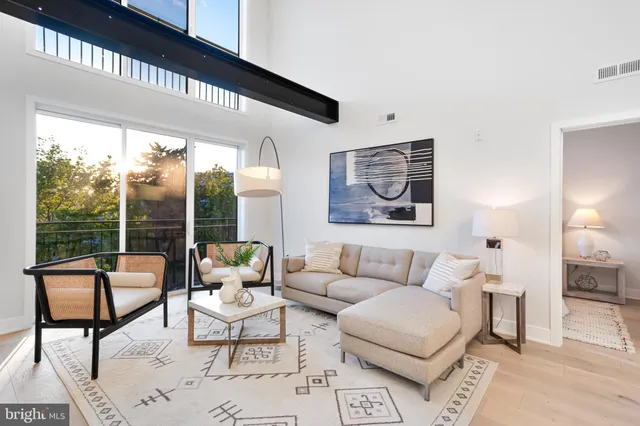 a living room with furniture and a floor to ceiling window