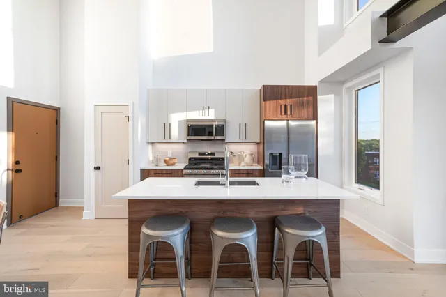 a kitchen with a dining table chairs and refrigerator