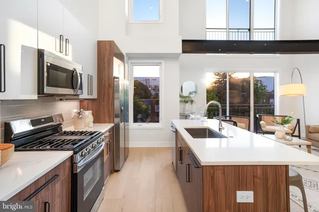 a kitchen with stainless steel appliances a sink stove and microwave