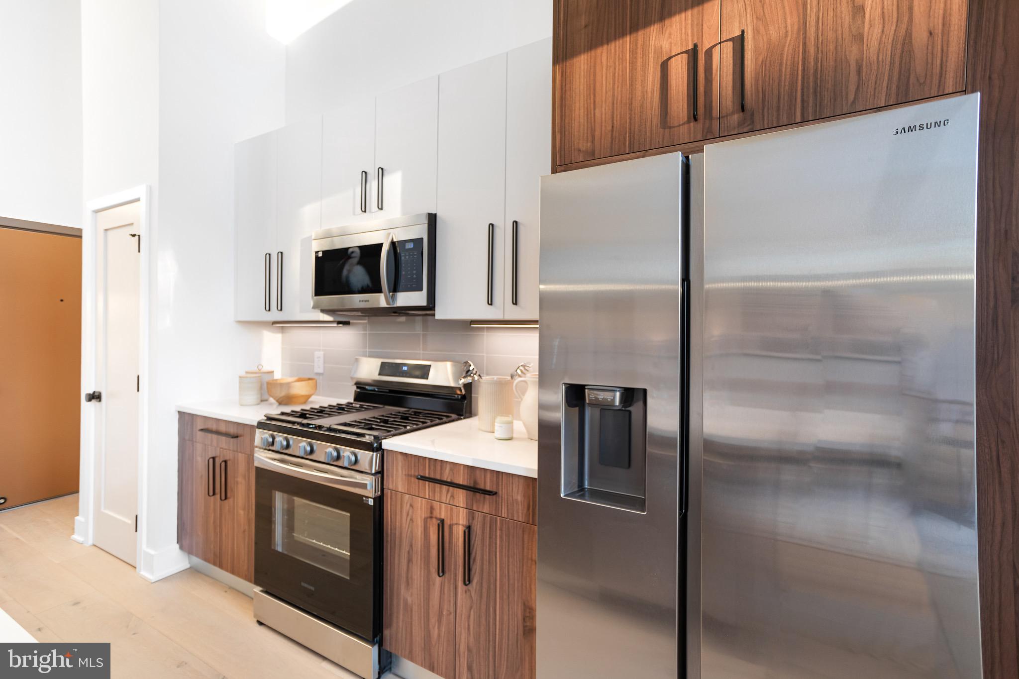 845 19th Street Northeast, Unit 10 Washington, DC 20002 - Photo 8 of 22 a kitchen with a refrigerator a microwave a sink and cabinets
