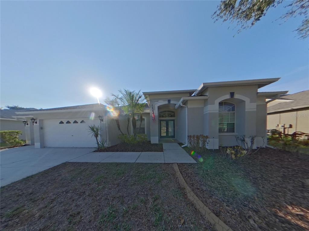 a view of a house with a yard and potted plants