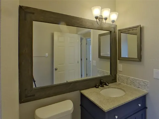 a bathroom with a sink vanity granite and a mirror