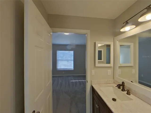 a bathroom with a sink mirror and vanity