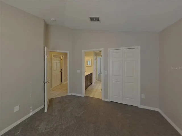 an empty room with closet and mirror