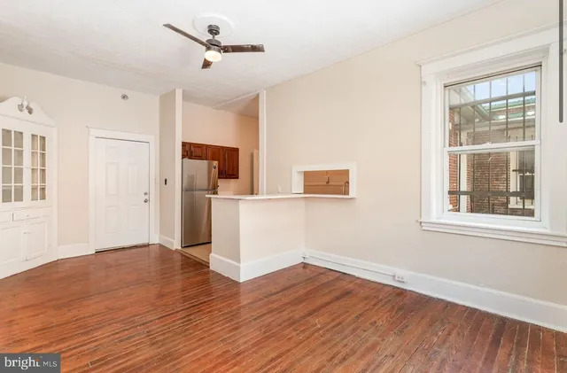 a view of empty room with wooden floor and windows