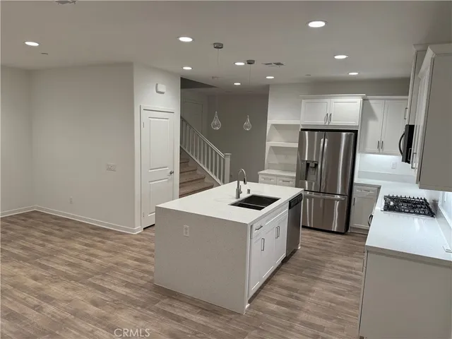 a kitchen with stainless steel appliances a sink a stove a refrigerator and cabinets