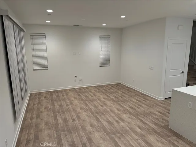 an empty room with wooden floor and entrance