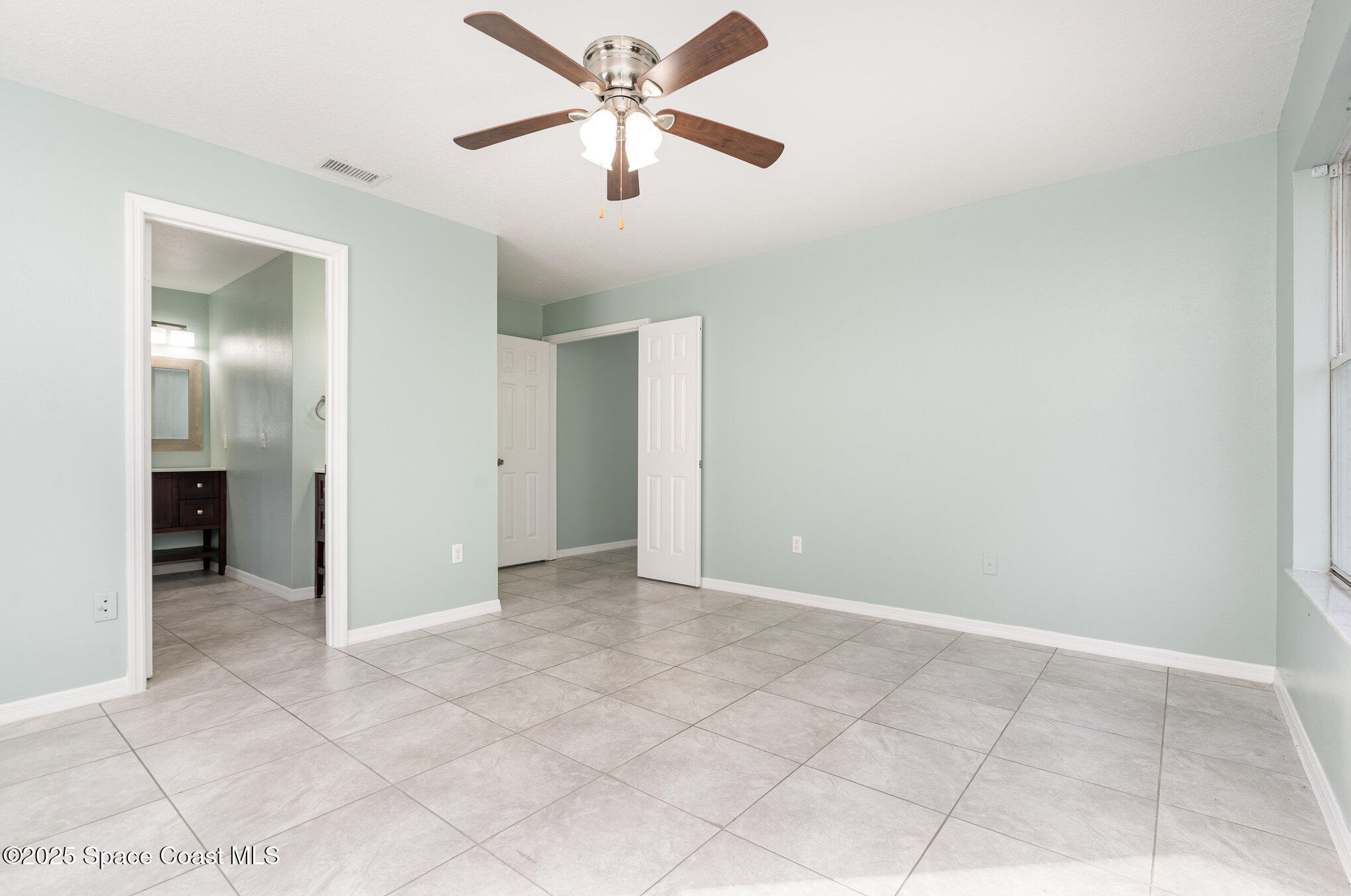 636 Fishtail Palm Boulevard Melbourne, FL 32901 - Photo 14 of 25 an empty room with closet and a ceiling fan
