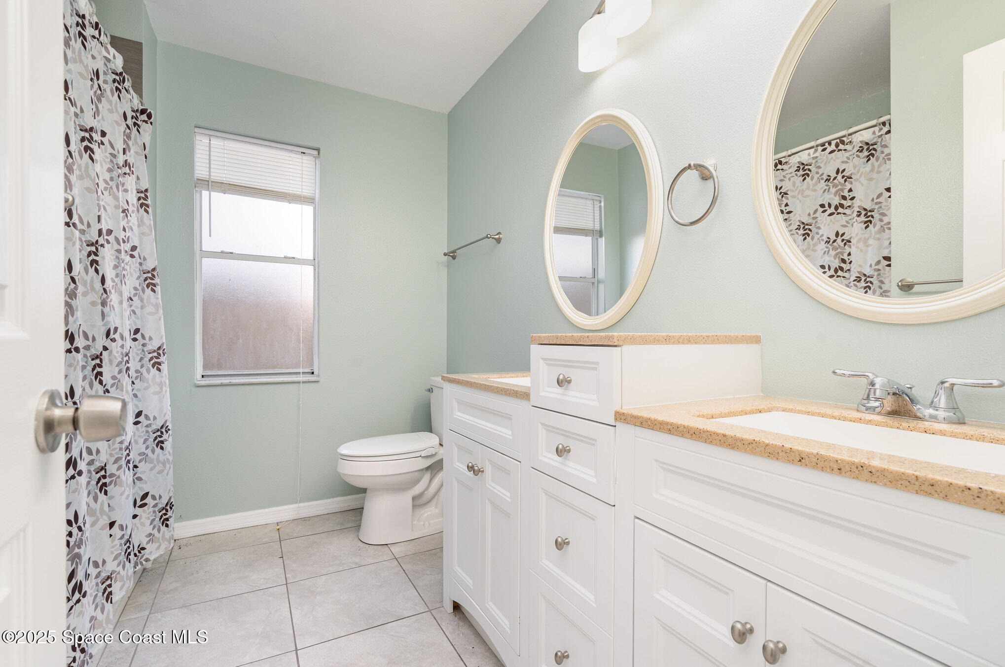 636 Fishtail Palm Boulevard Melbourne, FL 32901 - Photo 18 of 25 a bathroom with a toilet a sink and a mirror