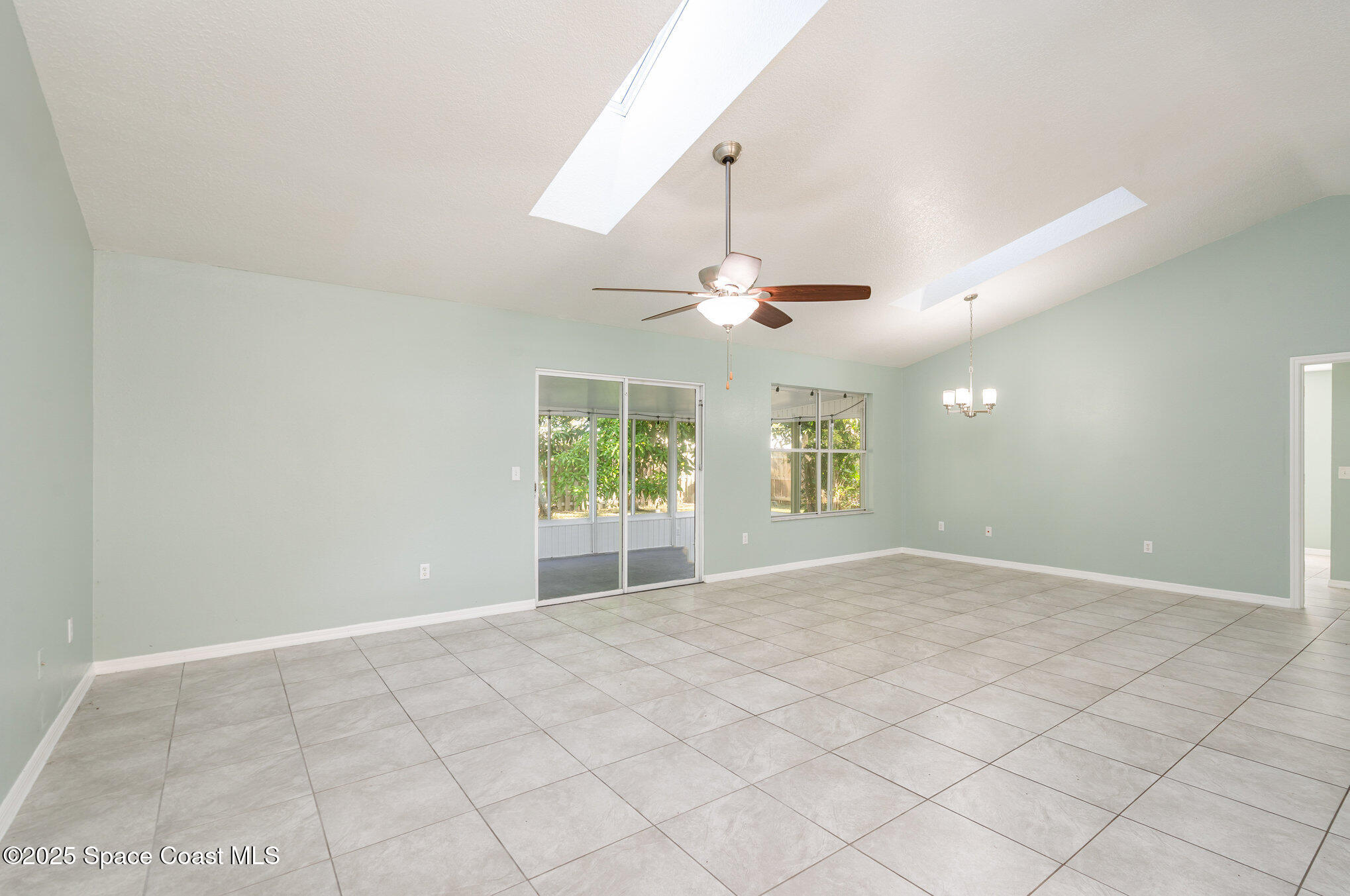 636 Fishtail Palm Boulevard Melbourne, FL 32901 - Photo 3 of 25 an empty room with windows and chandelier fan