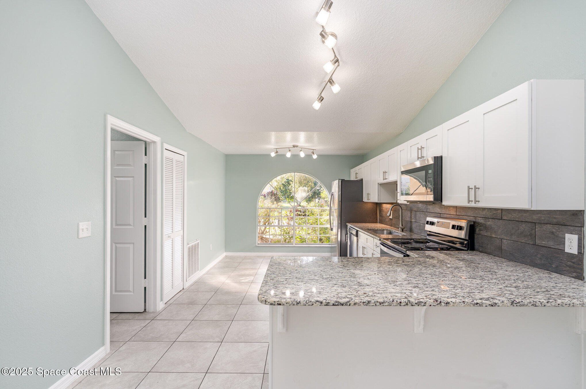 636 Fishtail Palm Boulevard Melbourne, FL 32901 - Photo 9 of 25 a kitchen with granite countertop a sink a stove and cabinets