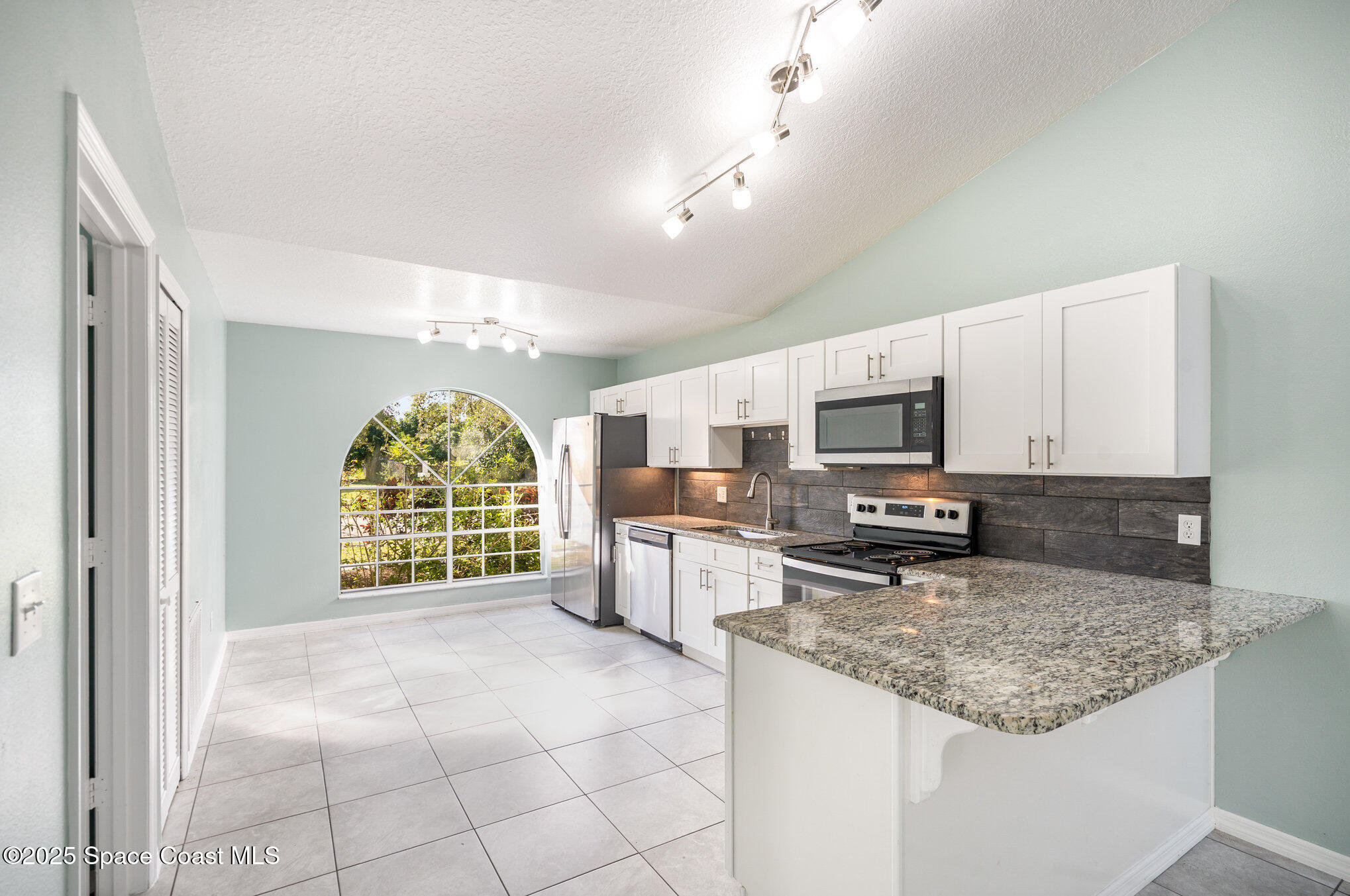 636 Fishtail Palm Boulevard Melbourne, FL 32901 - Photo 10 of 25 a kitchen with stainless steel appliances granite countertop a stove oven and a sink