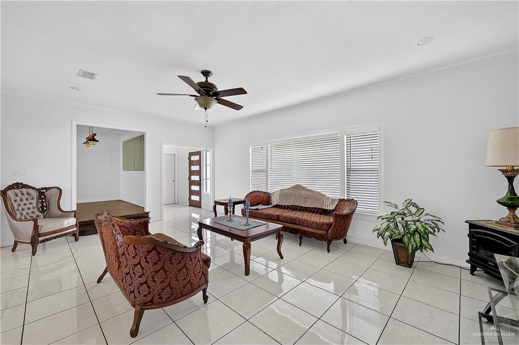 216 West Enfield Road Edinburg, TX 78539 - Photo 7 of 20 White tile flooring, large windows with blinds, ceiling fan, recessed lighting, and a paneled entry door