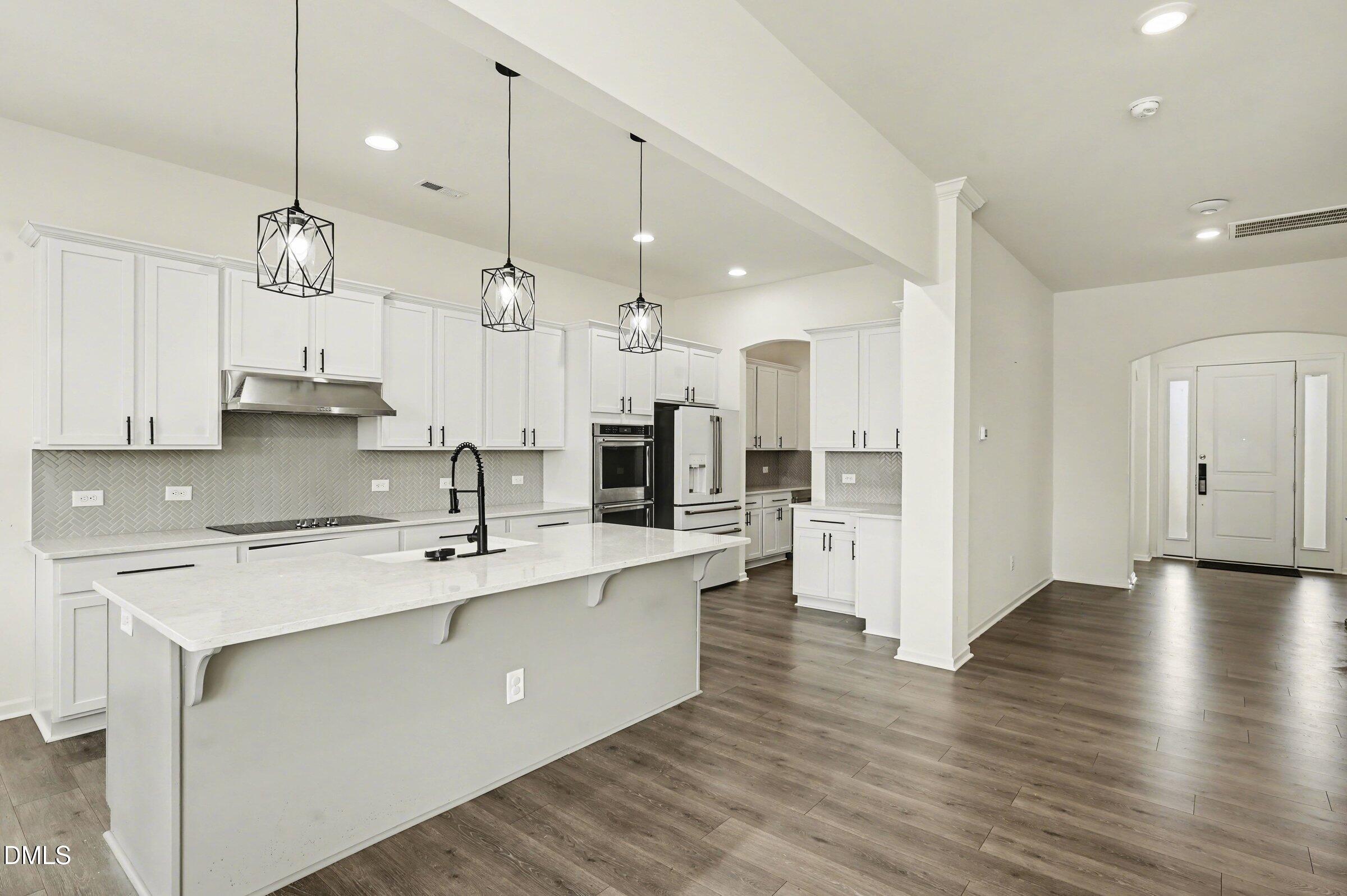 7015 Grainfield Road Mebane, NC 27302 - Photo 13 of 42 a large kitchen with stainless steel appliances kitchen island a large counter top space a sink refrigerator and cabinets