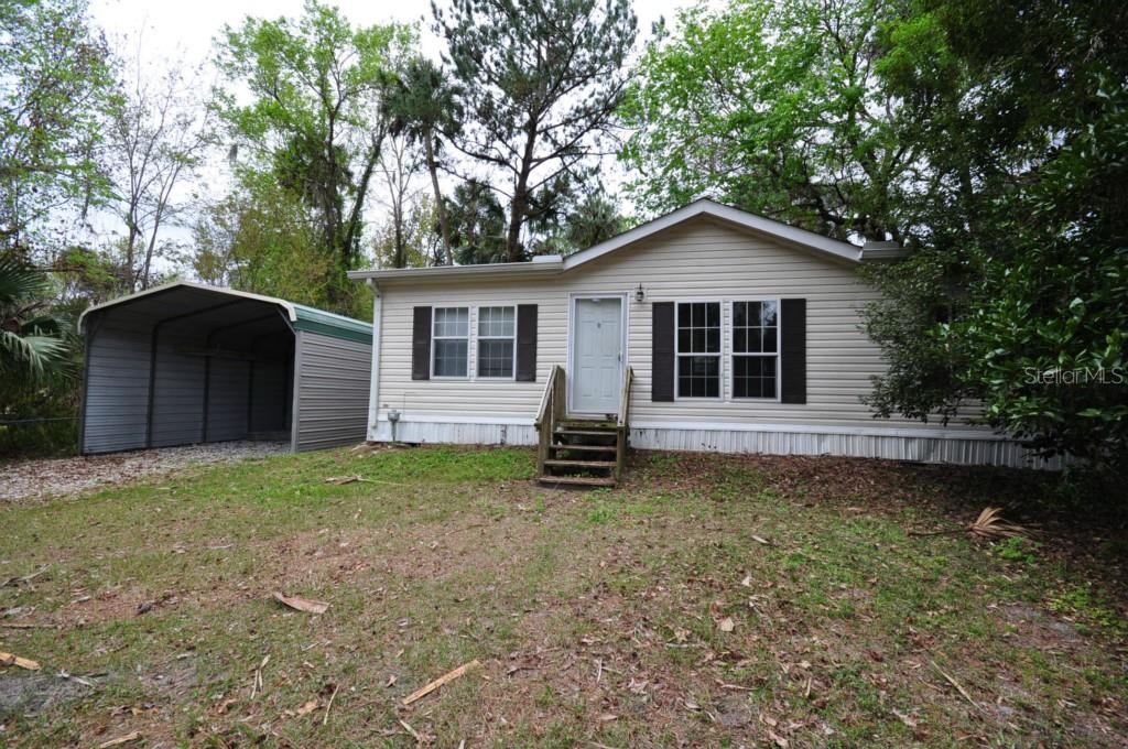 23938 Chestnut Road Astor, FL 32102 - Photo 1 of 1 a house with trees in the background