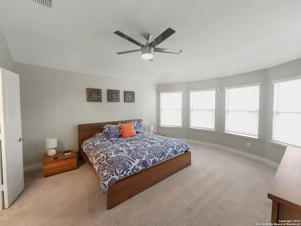 a large bedroom with a bed and large windows