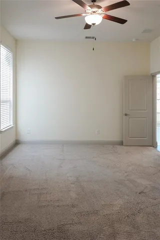an empty room with chandelier fan