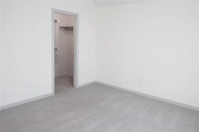 an empty room with a windows and ceiling fan